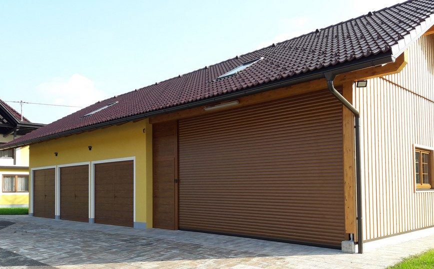 Rolo garažna vrata v imitaciji zlatega hrasta ob leseni fasadi