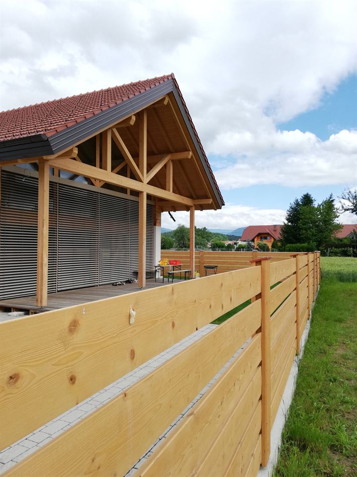 Zunanje žaluzije na pokriti terasi nove hiše z lesenim ostrešjem